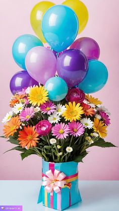 a bouquet of colorful flowers and balloons in a blue gift box on a pink background