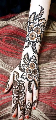 a woman's hand with henna tattoos on it