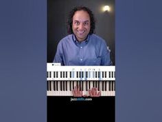 a man is smiling and playing the piano keyboard with his hands in front of him