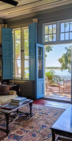 a living room filled with furniture next to a large open door leading to a patio