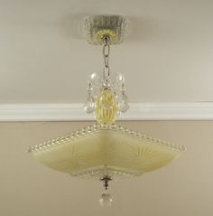 a chandelier hanging from the ceiling in a room with beige walls and white trim