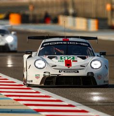 two cars racing on a race track with lights on the front and side of them