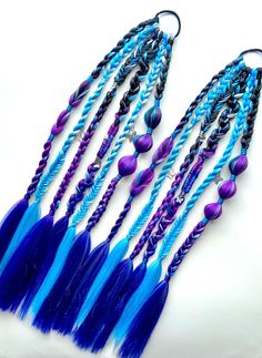 Set of Tie-In Braids Purple/Blue/Black 6 braids each + hair charms 23" long  * Great for parties, birthdays, festivals, concerts, etc * Handmade tie in braid extensions * Reusable - wear again & again * Super easy to attach to your own hair                     🧡  💛  💚  💙  💜   This braid is made with bubble braids, infinity braids, rope braids, 3 strand braids, snake braids, fishtail braids and 4 strand round braids. Made from a lightweight custom blend of synthetic hair in purple, blue and black colors.  Accessorized with hair charms.                     🧡  💛  💚  💙  💜 CARE INSTRUCTIONS: * Avoid Heat. Synthetic braids cannot withstand heat styling so avoid using hot styling tools to prevent melting or damage. * Storing. When not wearing, it's best to either hang them up or lay fla Snake Braids, 6 Braids, Braids Purple, Infinity Braids, 4 Strand Round Braid, Braids Fishtail, Snake Braid