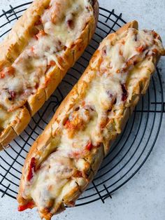 two cheesy breads sitting on top of a wire rack