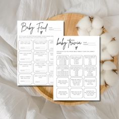 the baby food chart is next to cotton floss on a wooden plate with white sheets