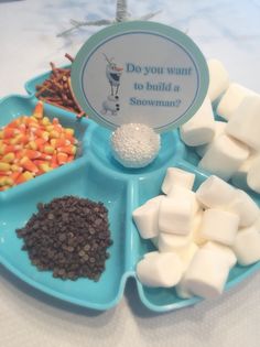 a blue tray filled with marshmallows, chocolate and candy