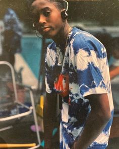 a young man wearing headphones standing next to a chair