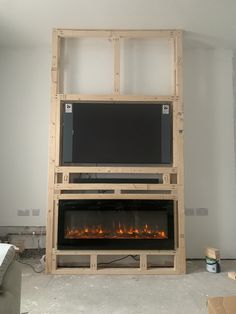 a large television mounted to the side of a wall with a fire place in it