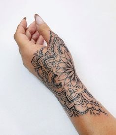 a woman's arm with a tattoo on it and a hand holding the wrist