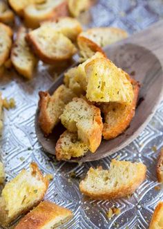 a spoon full of garlic bread on top of a table