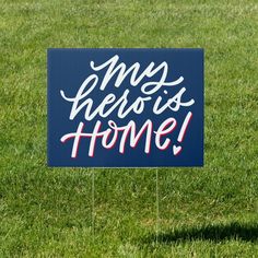 a yard sign that says, our hero is home on top of some green grass