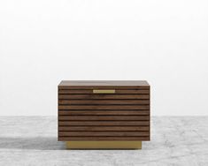 a wooden box sitting on top of a cement floor next to a white wall in the background