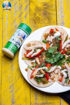 a plate filled with tacos and vegetables next to a bottle of mayonnaise