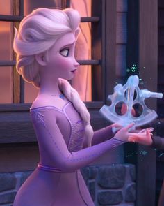 the frozen princess is holding an object in her hand and looking at it's reflection