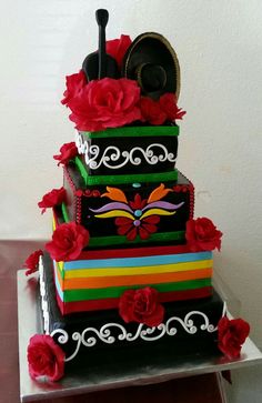 a multi - tiered cake with red flowers on top