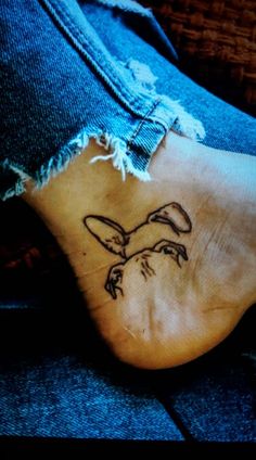 a person's foot with a small tattoo on the side of their leg,