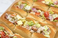 many hot dogs with different toppings are lined up on a cutting board and ready to be eaten