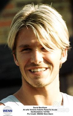 a man with blonde hair smiling at the camera