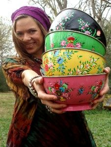 a woman is holding several bowls in her hands