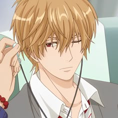 a young man with blonde hair and red eyes is wearing headphones while sitting in a car