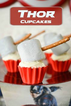 cupcakes with white frosting and marshmallows on top are sitting on a glass plate