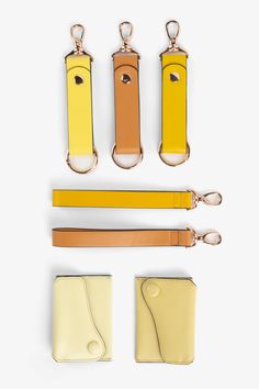 four pieces of yellow leather with keychains and clippings on white background