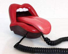 an old fashioned telephone with a red mouth and white teeth