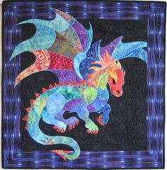 a colorful dragon quilt hanging on a wall next to a black background with blue and purple stripes