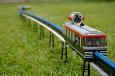 there is a toy train going down the track in the grass with another set on it