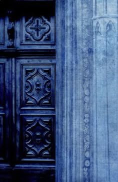 an old door with ornate carvings on the outside and inside, in blue hues