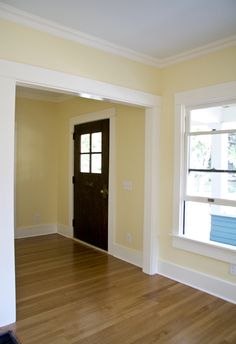 an empty room with hard wood floors and yellow walls