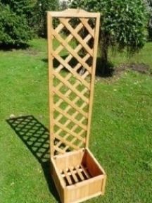 a tall wooden planter sitting on top of a lush green field