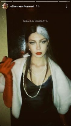 a woman in black dress and white fur coat with red gloves on her arm, posing for the camera