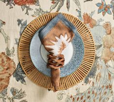 a place setting on a floral table cloth