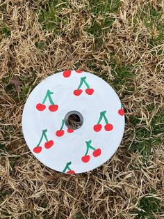 a paper plate with cherries on it sitting in the grass