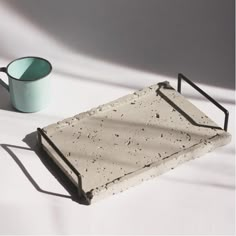 a tea tray with a cup on it and a shadow cast on the wall behind it