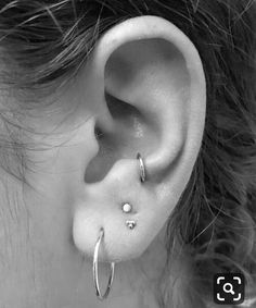 a close up of a person's ear with two piercings