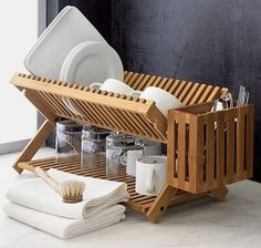 a wooden dish rack with dishes and utensils in it