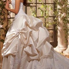 a woman in a wedding dress posing for the camera