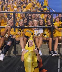 a group of women in yellow shirts sitting next to each other on bleachers