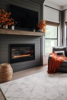 a living room with a couch, fireplace and large windows