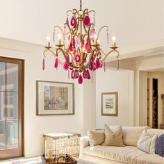 a chandelier hanging from the ceiling in a living room next to a couch