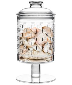 a glass container filled with shells on top of a table