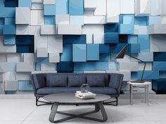 a living room with blue and white squares on the wall behind a couch, coffee table and lamp