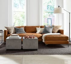 a living room filled with lots of furniture and large windows in the wall behind it