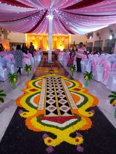 an elaborately decorated hall with white chairs and pink draping on the ceiling