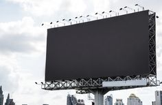 a large billboard with birds sitting on it's sides in front of a city skyline