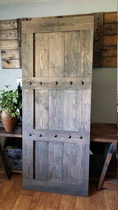 an old wooden door sitting on top of a hard wood floor next to a potted plant