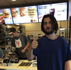 a man giving the thumbs up at a fast food restaurant