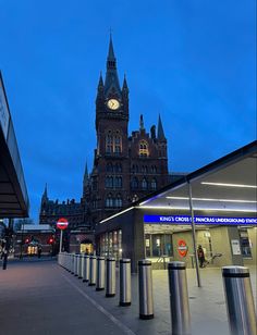 a large building with a clock tower in the middle of it's side walk